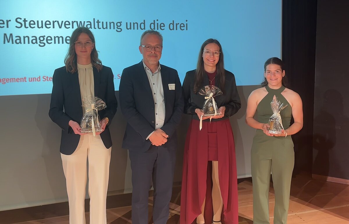 Ministerialdirektor Engling mit den Absolventinnen auf der Bühne