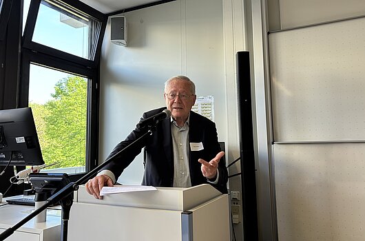Ulrich Müller präsentiert sein Buch zur politischen Kultur in Ludwigsburg Ulrich Müller steht an einem Rednerpult und spricht vor Publikum über sein Buch "Kompass politische Kultur".