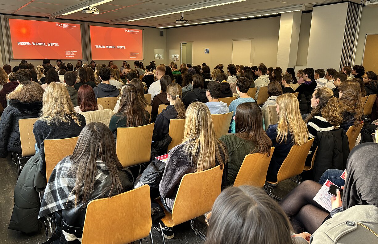 Gefüllter Hörsaal am Studieninfotag der HVF Ludwigsburg, Studieniteressierte hören den Vorträgen zu.