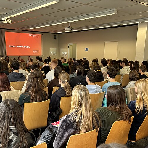 Gefüllter Hörsaal am Studieninfotag der HVF Ludwigsburg, Studieniteressierte hören den Vorträgen zu.