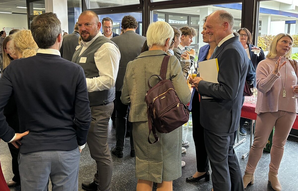 Zahlreiche Gäste beim Empfang zur Amtseinführung von Kanzler Markus Dammler an der HVF, im Gespräch und mit Sektgläsern.