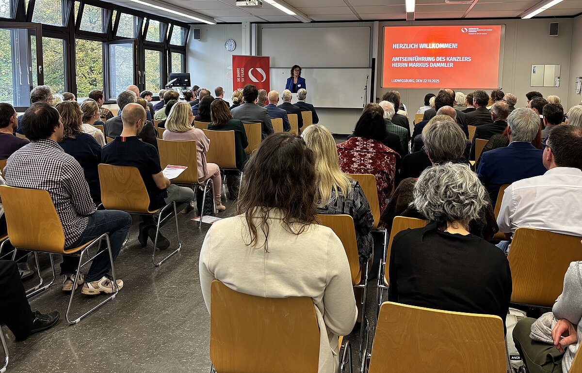 Rektorin Dr. Iris Rauskala eröffnet die feierliche Amtseinführung von Kanzler Markus Dammler vor vollem Hörsaal an der HVF.