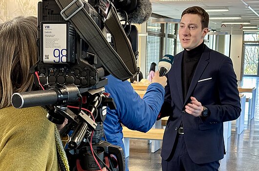 Der jüngste Bürgermeister Deutschlands, Jan Jäckel (HVF Student), wird von einer SWR-Journalistin im Freien interviewt.