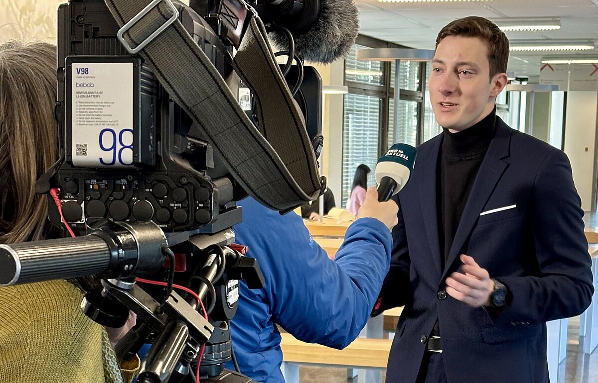 Jan Jäckel_Bürgermeister Asselfingen Der jüngste Bürgermeister Deutschlands, Jan Jäckel (HVF Student), wird von einer SWR-Journalistin im Freien interviewt.