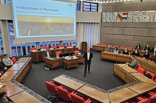 OB Peter Boch begrüßt HVF-Studierende im Sitzungssaal des Rathauses Pforzheim bei einer Exkursion im Rahmen eines Fachprojekts.