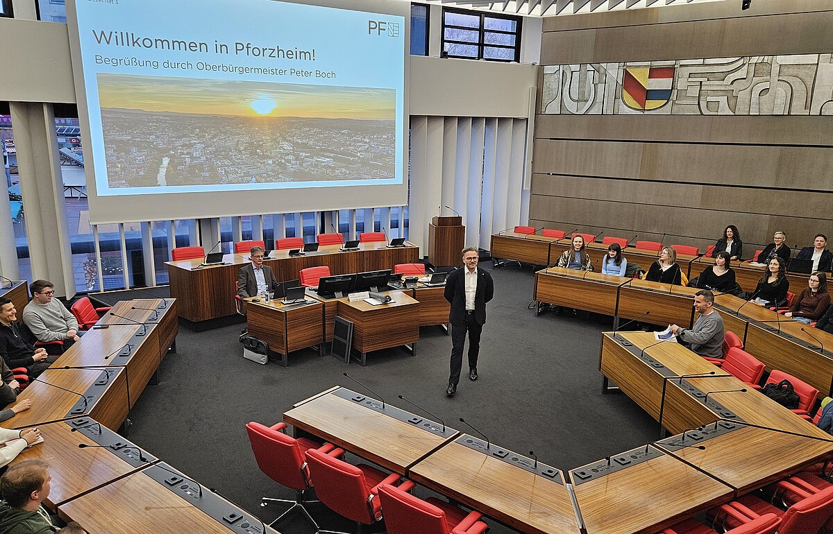 OB Peter Boch begrüßt HVF-Studierende im Sitzungssaal des Rathauses Pforzheim bei einer Exkursion im Rahmen eines Fachprojekts.
