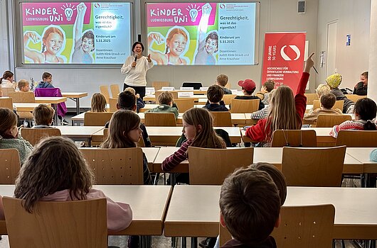 Prof. Dr. Judith Klink-Straub (HVF) beginnt die Vorlesung der Kinderuni 2025 zum Thema "Gerechtigkeit" vor vielen Kindern.