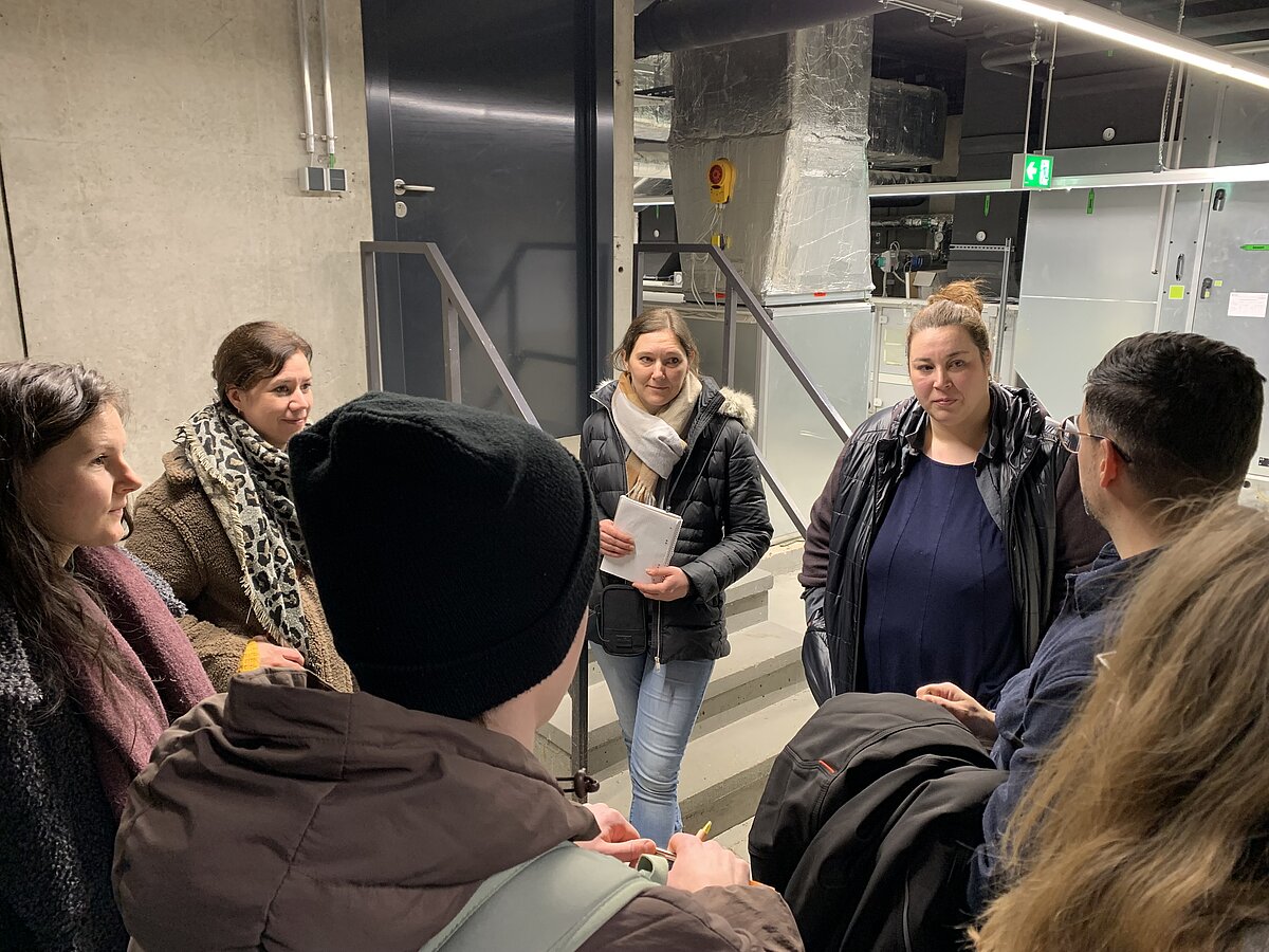 Die Begehungsrunde tauscht sich zu Sanierungszielen am Campus aus.