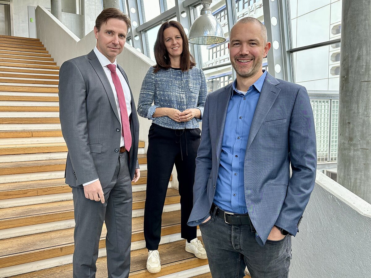 Professoren Sauerland, Steidle und Englert vom Institut für Organisation, Personal und Arbeit der HVF stehen auf einer Treppe.