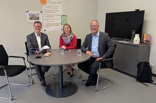 Der neue Kanzler der Hochschule für öffentliche Verwaltung und Finanzen Ludwigsburg, Markus Dammler (links), im Gespräch mit der Verbandsvorsitzenden Sarina Pfründer (Mitte) und dem Verbandsgeschäftsführer Tilmann Schmidt (rechts). Das Treffen fand in einem Besprechungsraum der Hochschule statt.
