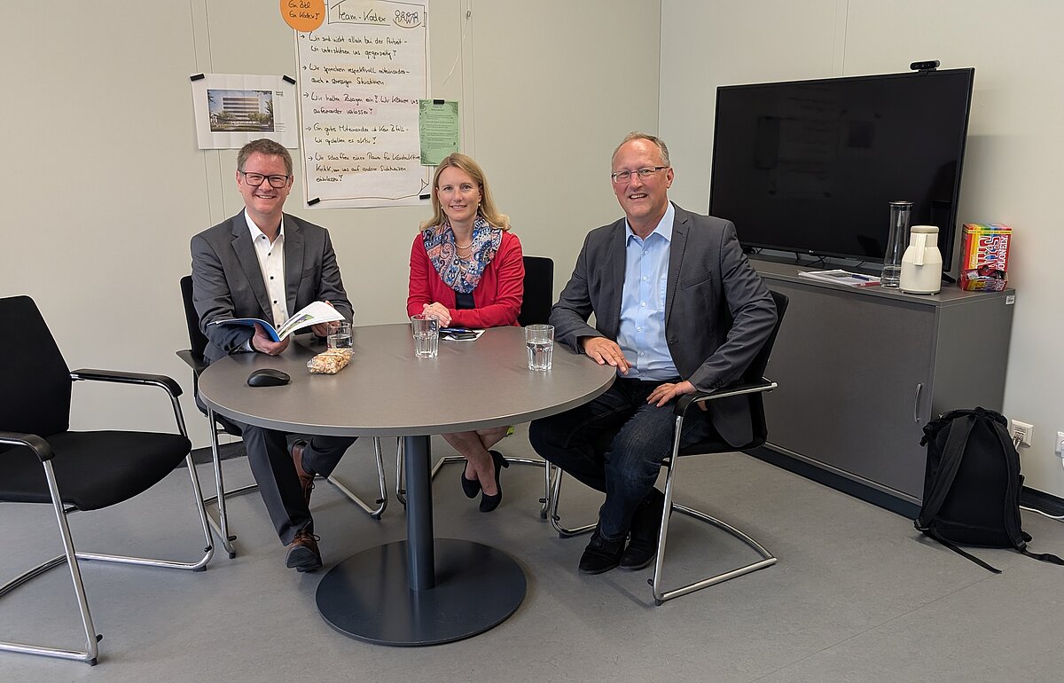 Der neue Kanzler der Hochschule für öffentliche Verwaltung und Finanzen Ludwigsburg, Markus Dammler (links), im Gespräch mit der Verbandsvorsitzenden Sarina Pfründer (Mitte) und dem Verbandsgeschäftsführer Tilmann Schmidt (rechts). Das Treffen fand in einem Besprechungsraum der Hochschule statt.