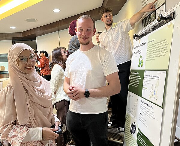 Studierende präsentieren ein wissenschaftliches Poster zum Thema „German Medical Technology“.