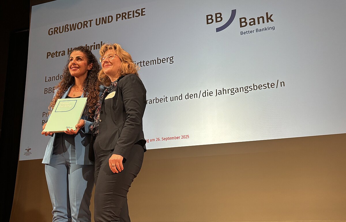 Georgia Toulkeridis (l.), beste Absolventin, erhält Preise von Petra Hasebrink (BBBank, r.) auf der Bühne.