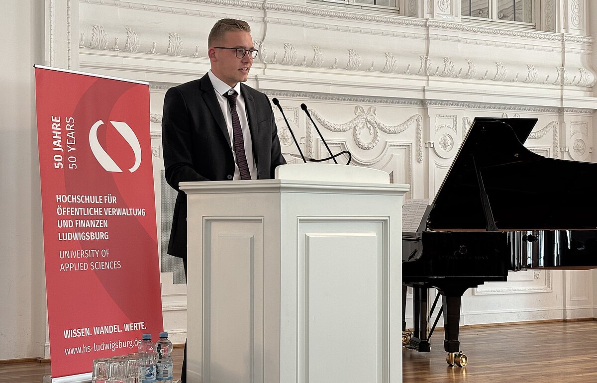 Julius Thölke (PFM-Absolvent) hält am Rednerpult die Jahrgangsrede für seinen Studiengang.