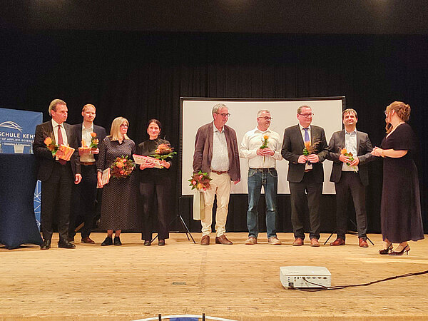 Absolventen des Master Europäischen Verwaltungsmanagement (MEPA) bedanken sich auf der Bühne.