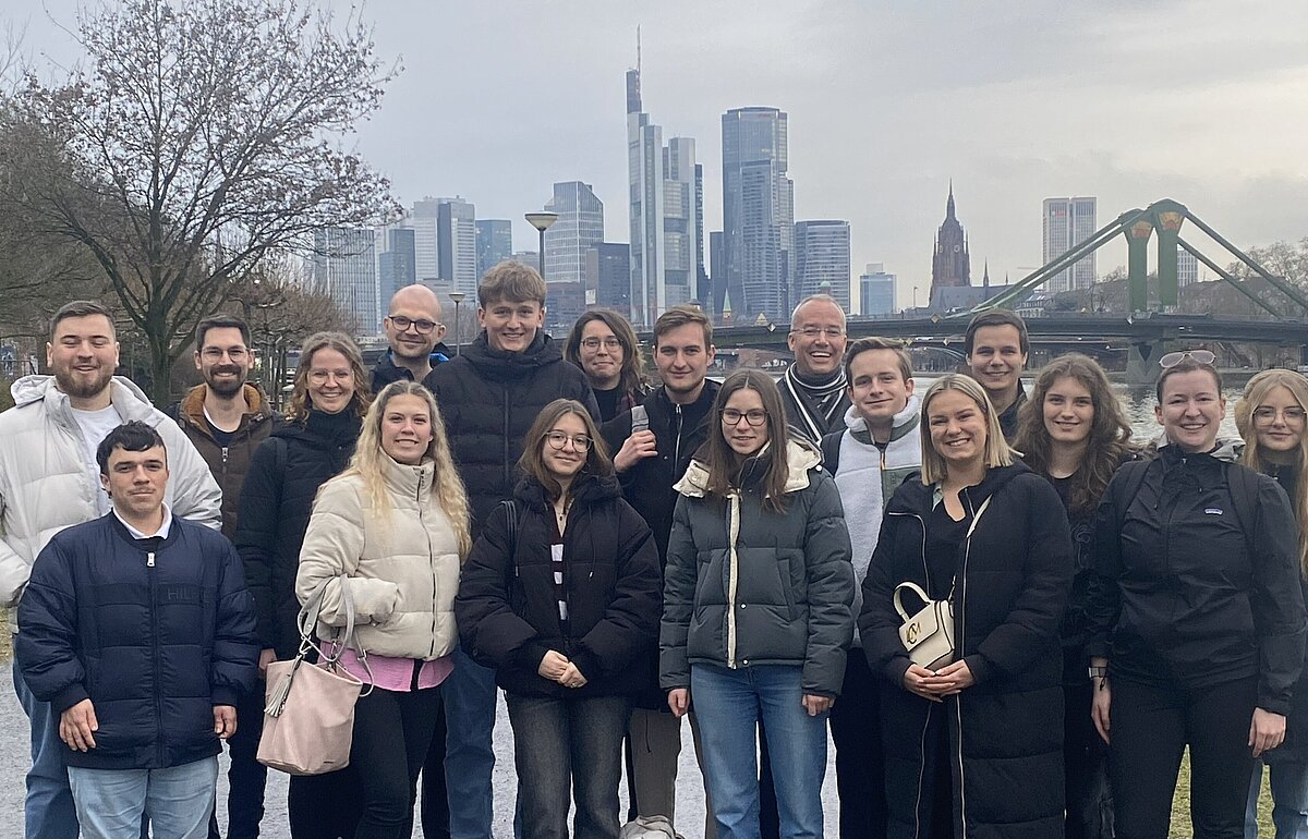DVM-Studierende und Prof. Mrass am Frankfurter Mainufer mit der Skyline und dem Eisernen Steg im Hintergrund.