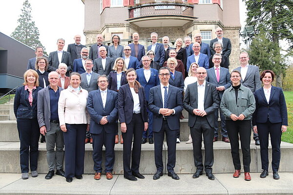 Gruppenfoto der Rektoren und Kanzler der HAW Baden-Württemberg mit Cem Özdemir und Thomas Poreski vor einem historischen Gebäude.
