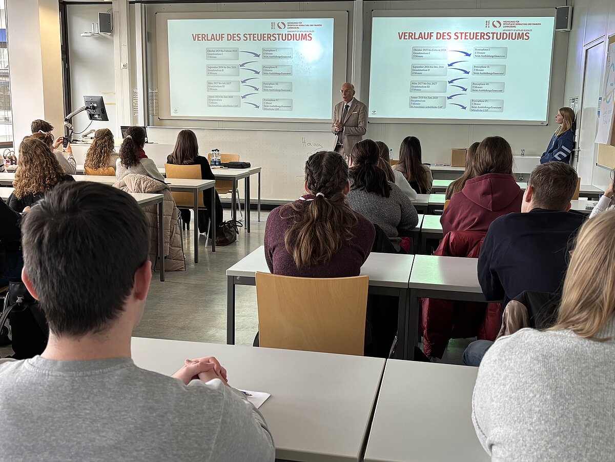 Dozent präsentiert den Studiengang Steuerverwaltung der HVF Ludwigsburg vor vielen Studieninteressierten.