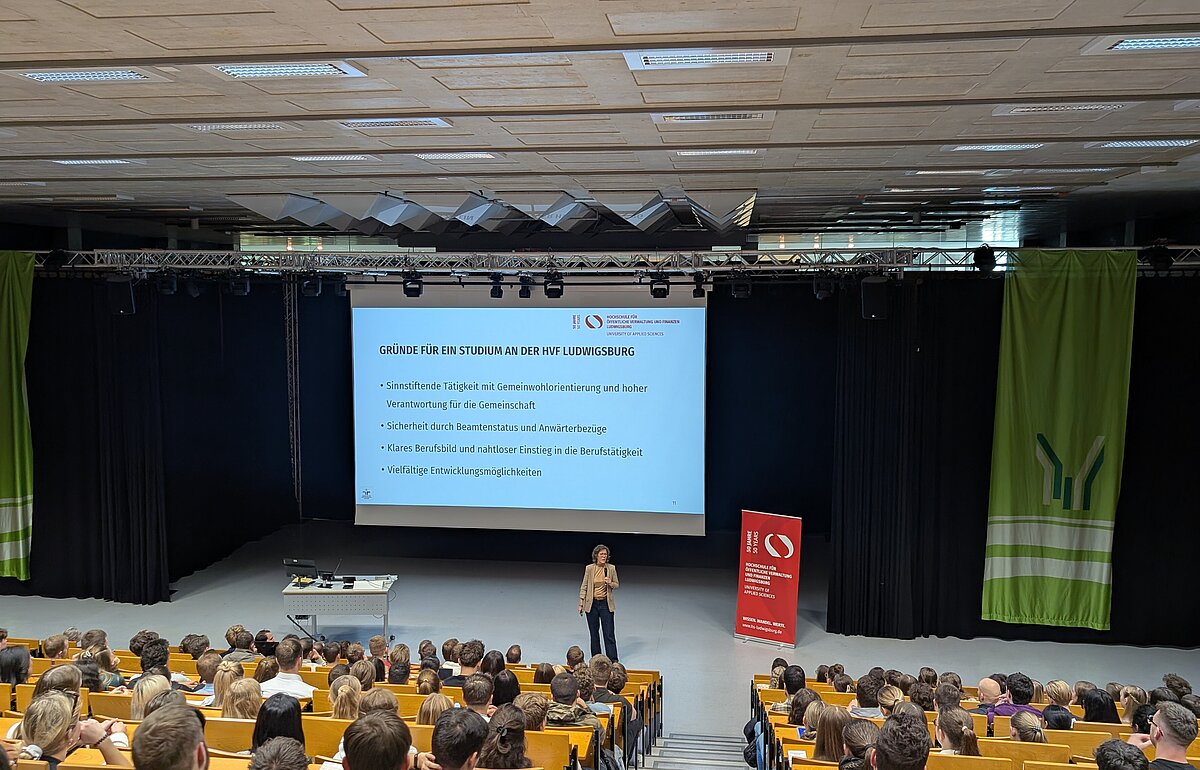 Einführungsveranstaltung Steuerverwaltung HVF Ludwigsburg: Rektorin hält Vortrag vor großem Publikum, Präsentation mit Studienvorteilen.