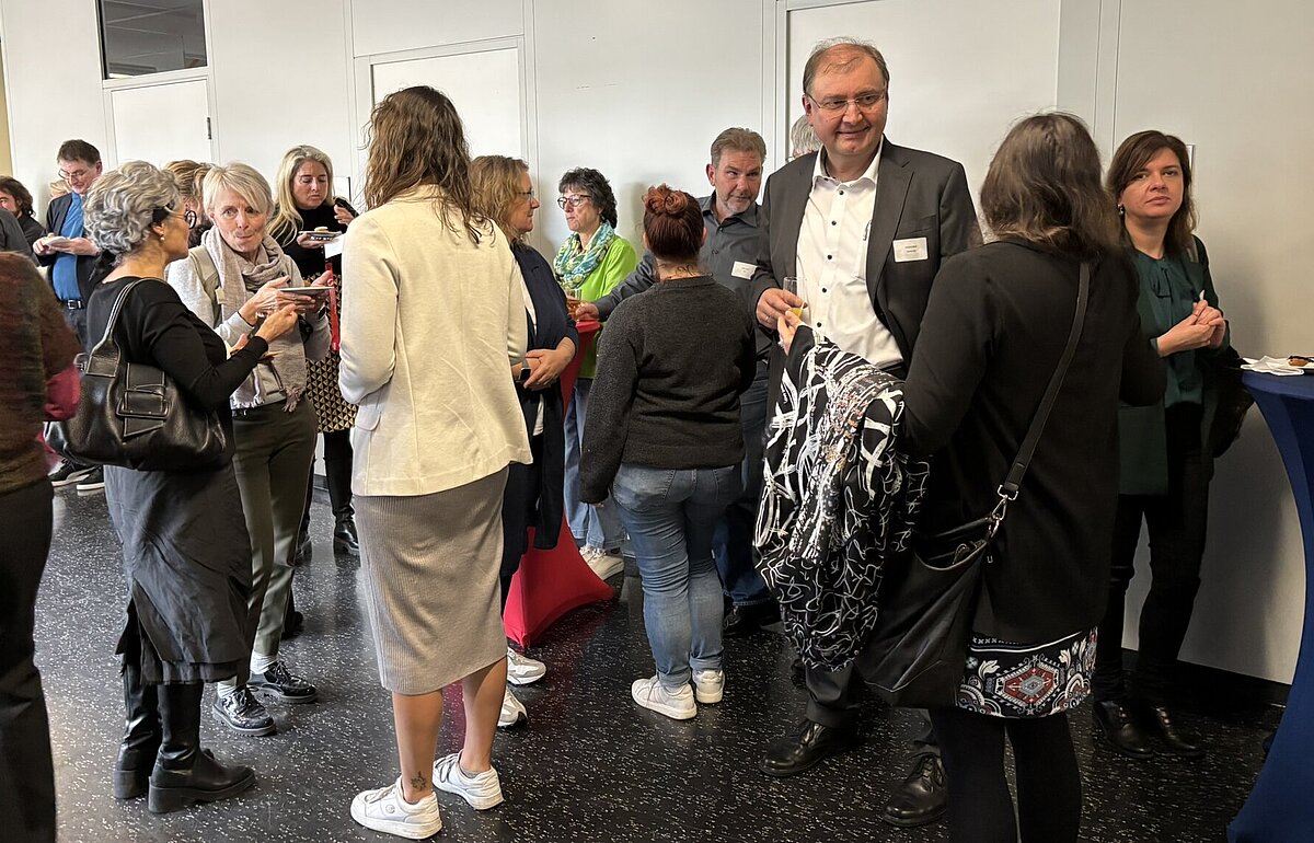 Gäste und Mitarbeitende der HVF im lockeren Austausch beim Empfang zur Amtseinführung von Kanzler Markus Dammler.