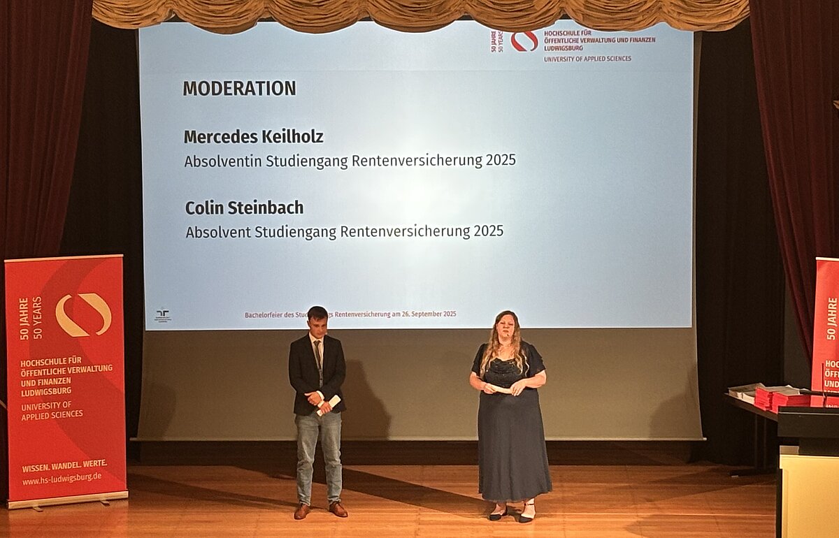 Die Absolvent:innen Mercedes Keilholz und Colin Steinbach moderieren die Bachelorfeier auf der Bühne.